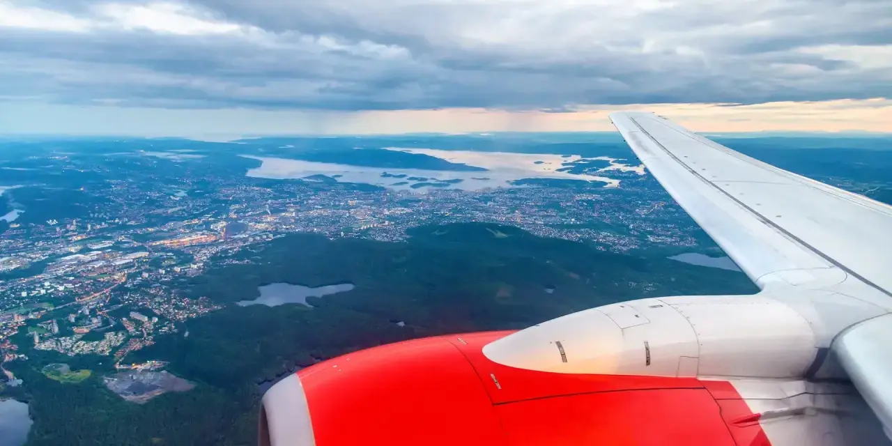 Widok z samolotu na Oslo i okoliczne fiordy, z widocznym skrzydłem i silnikiem.