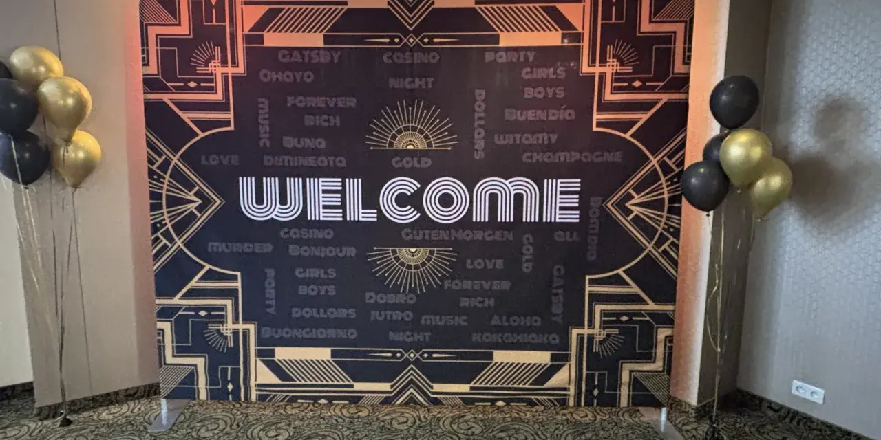 Tło w stylu lat 20. z napisem "WELCOME" i złotymi balonami.