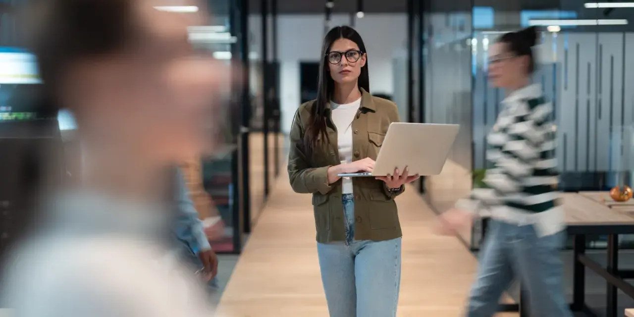 Femme avec un ordinateur portable dans un bureau moderne, préparant une annonce légale changement de gérant.