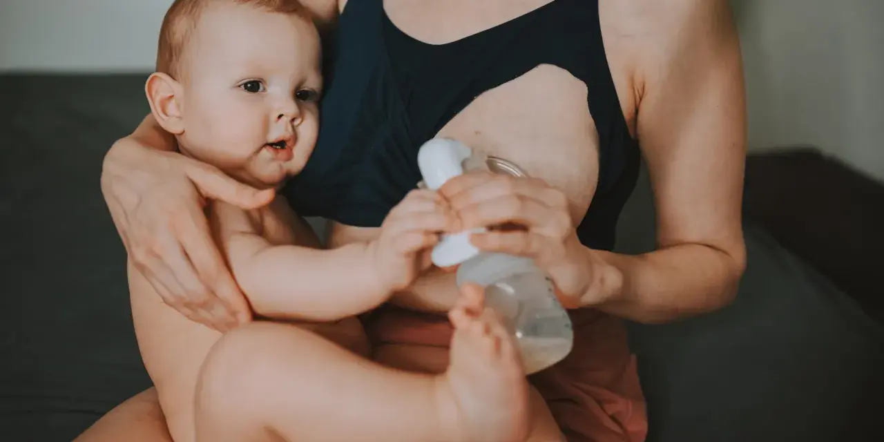 Mama karmi piersią i odciąga pokarm, pokazując, jak karmienie piersią a praca mogą iść w parze.