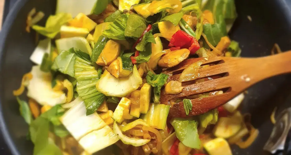 Kolorowe warzywa, w tym kapusta pak choi, smażone na patelni. Idealne do szybkich i zdrowych dań, inspiracja do kapusta pak choi przepisy.