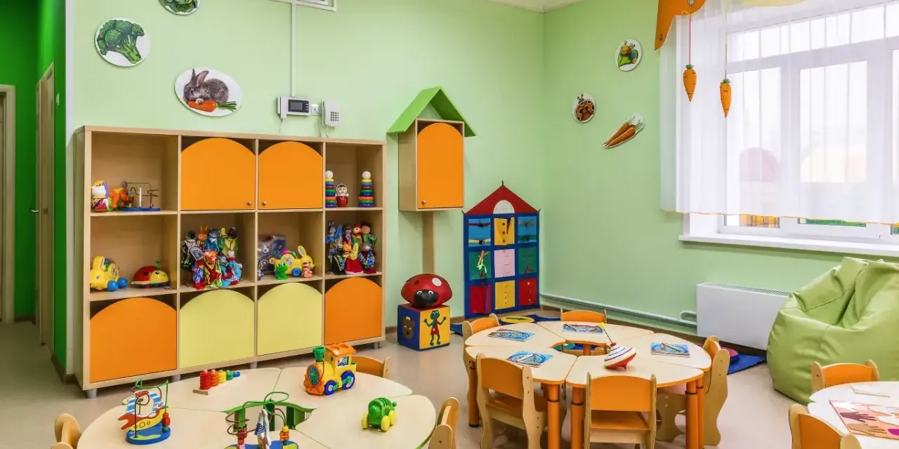 Kolorowy żłobek z zabawkami i stolikami. Czy żłobek jest płatny? To zależy od placówki, ale tutaj dzieci bawią się wesoło.