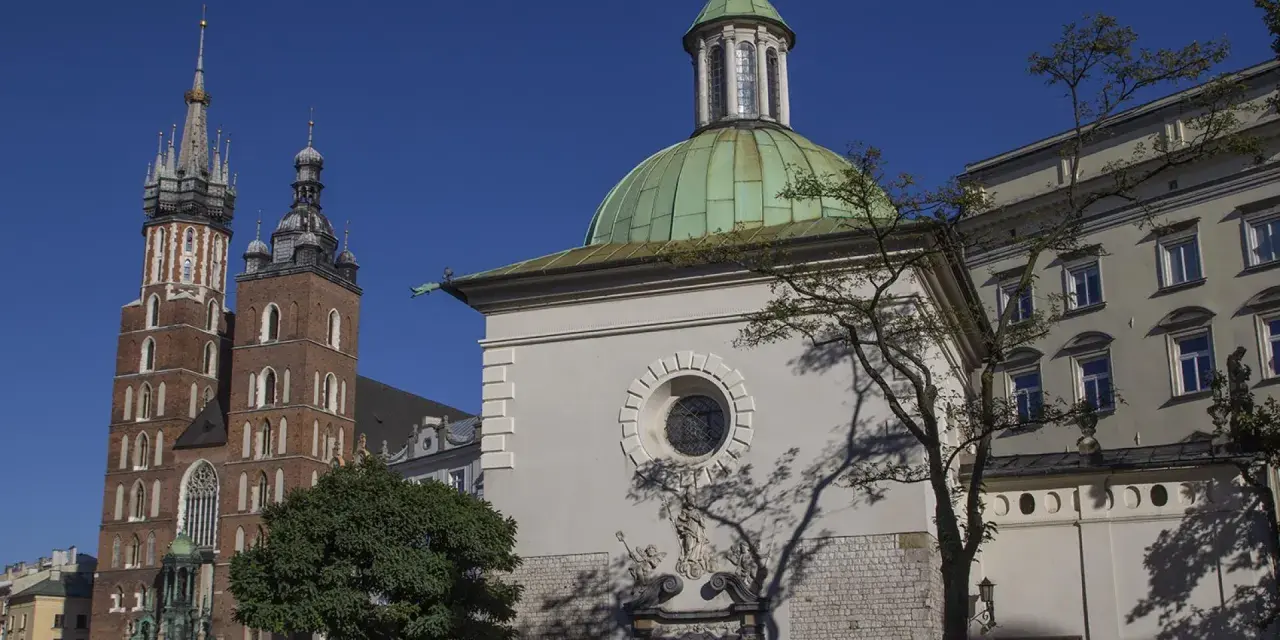 Kraków: Bazylika Mariacka i kaplica św. Klemensa, najstarszy kościół w Krakowie, pod błękitnym niebem.
