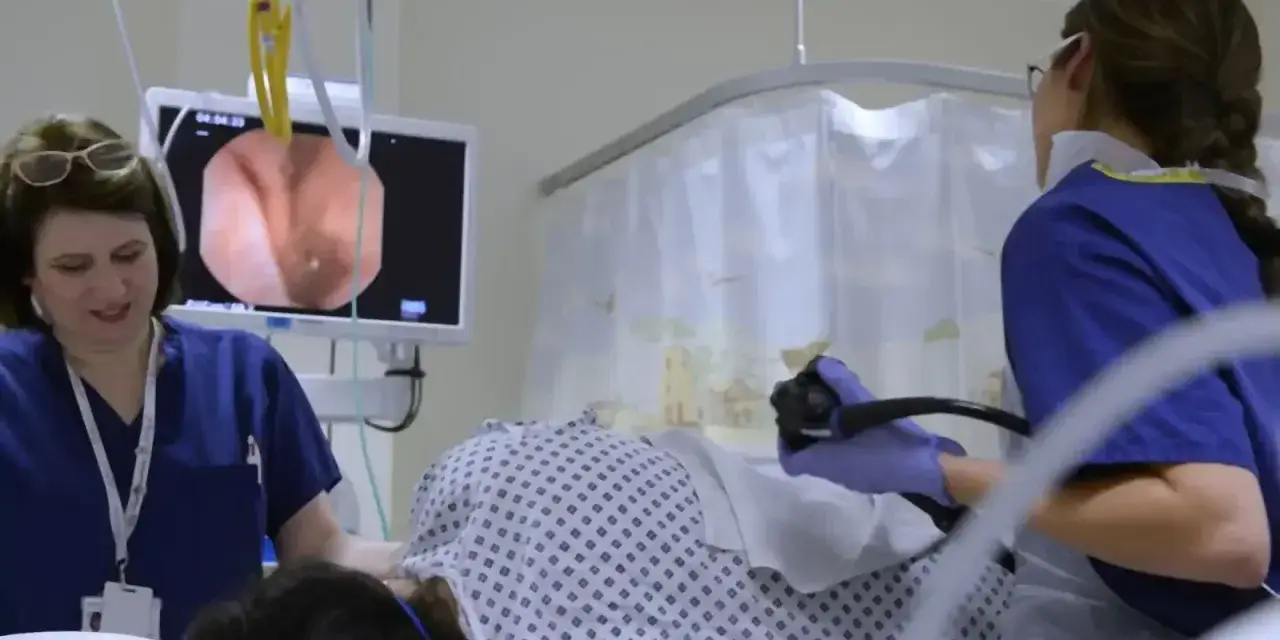 Lekarze przeprowadzają kolonoskopię, obserwując obraz z wnętrza jelita na monitorze.