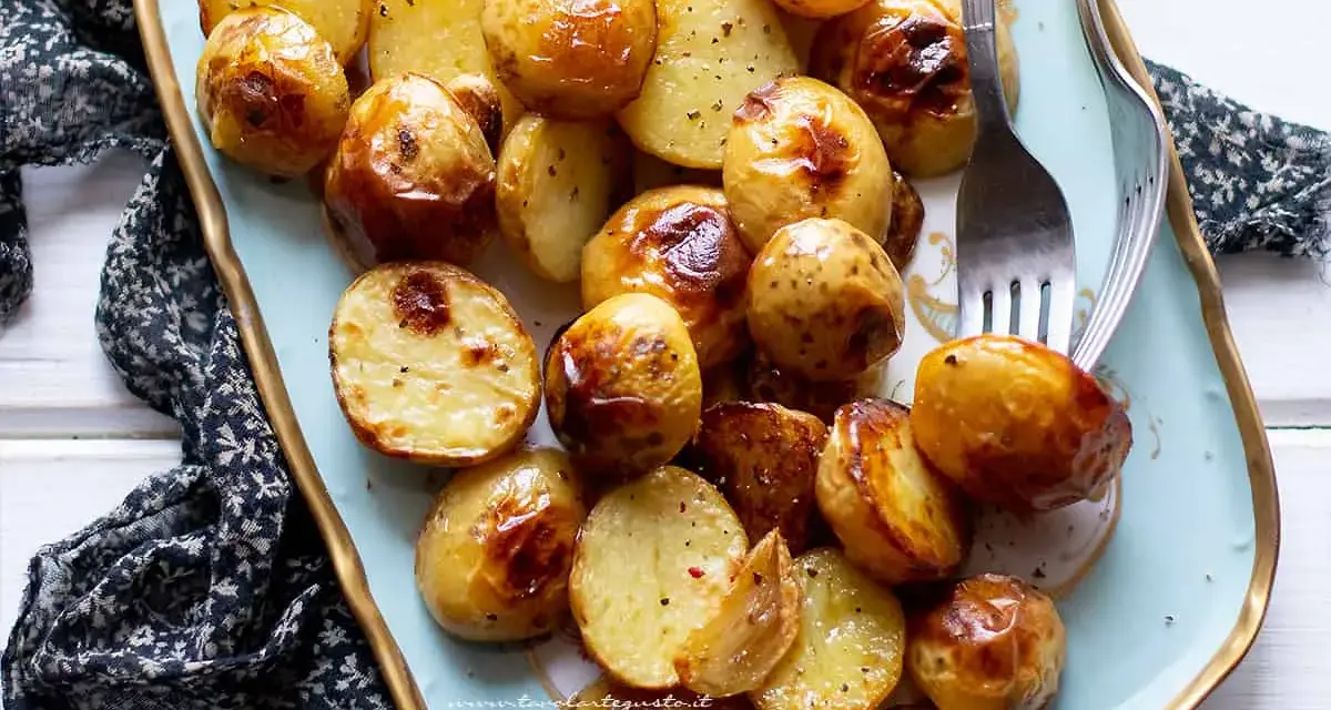 Patate novelle al forno dorate e croccanti, servite su un piatto decorato, pronte per essere gustate.