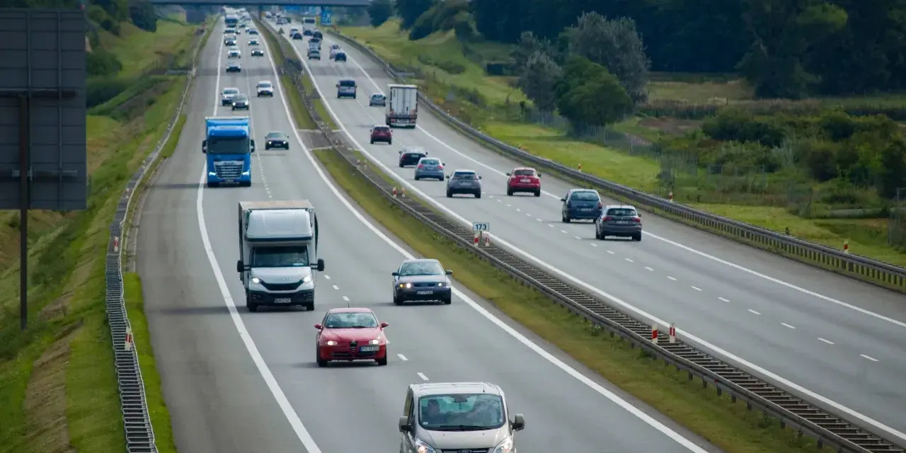 Ruch na autostradzie, gdzie samochody jadą różnymi pasami. Pytanie, czy na autostradzie można wyprzedzać z prawej strony, jest kluczowe dla bezpieczeństwa.