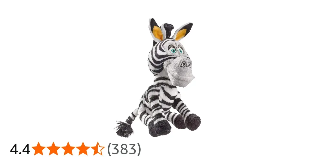 Pluszowa zebra z Madagaskaru, Marty, siedzi z szeroko otwartymi oczami i uśmiechem.