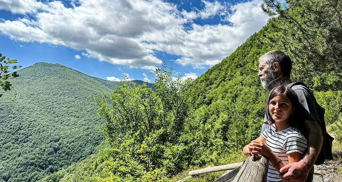 Un uomo e una bambina ammirano il panorama sui sentieri di Roccaraso, immersi nel verde lussureggiante delle montagne.