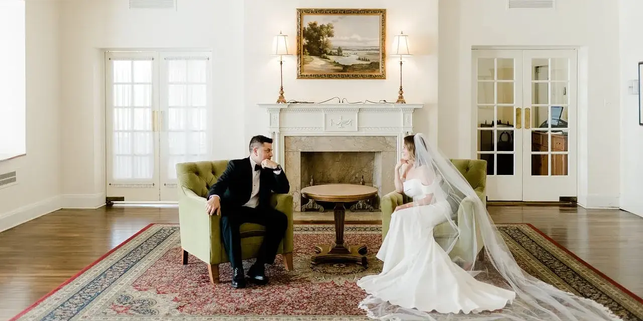 Para młoda w eleganckich strojach siedzi naprzeciwko siebie, rozmawiając o tym, co daje ślub cywilny.