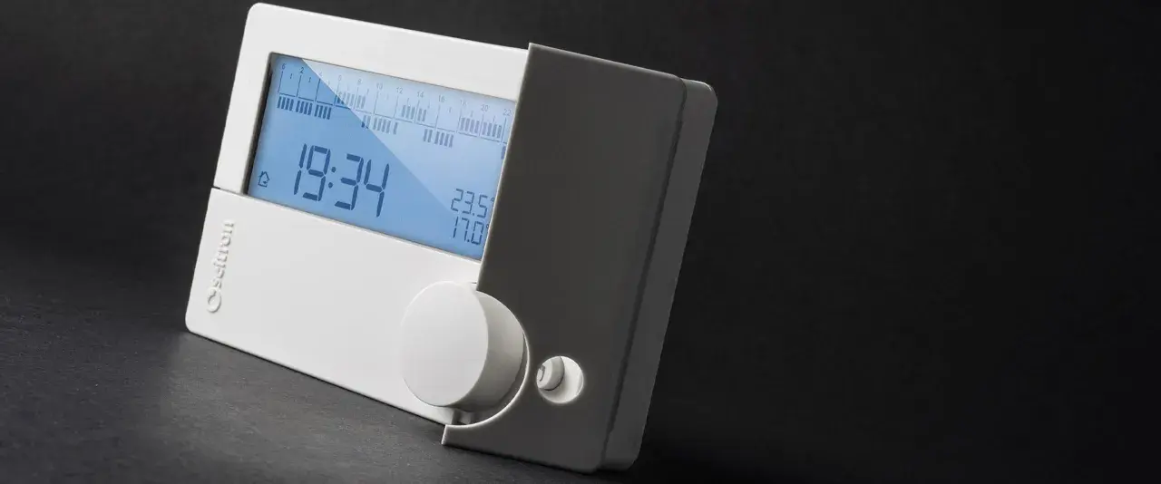 Cronotermostato cos'è? Un dispositivo digitale bianco con display blu che mostra ora, temperatura e programmazione.