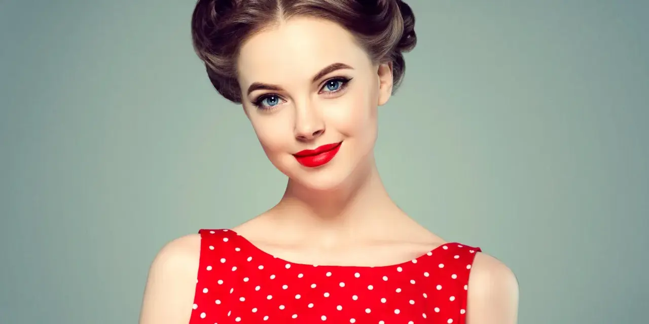 Eleganckie fryzury retro na wesele, z kręconymi kokami i czerwoną sukienką w grochy.