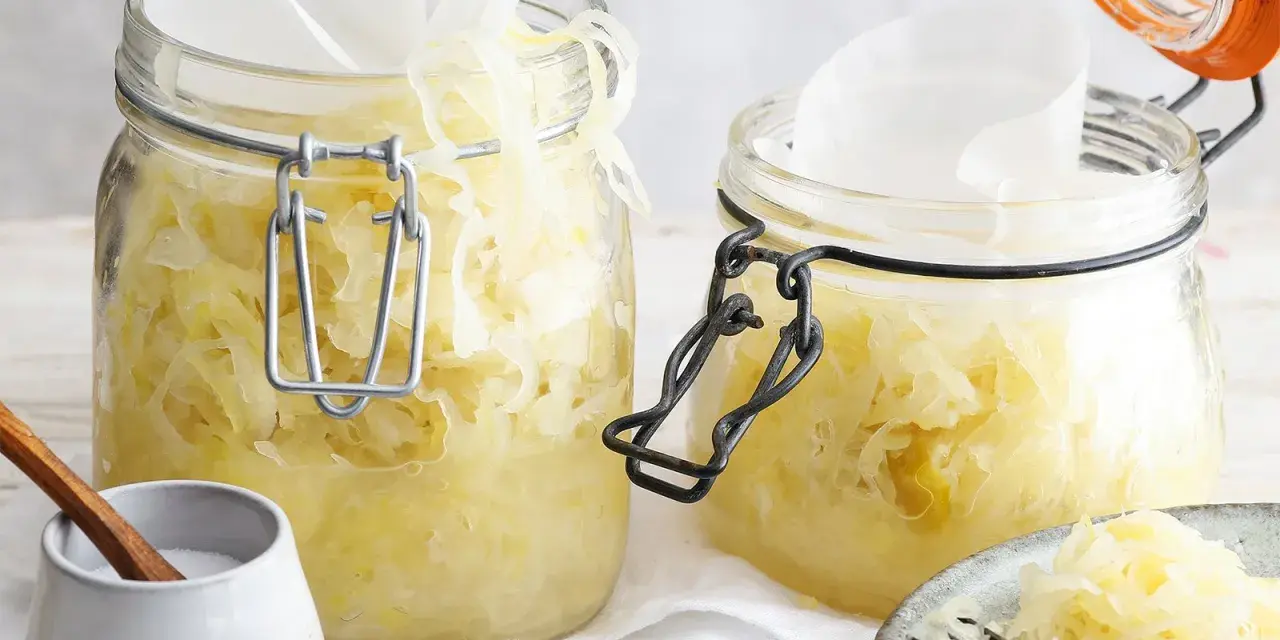Zwei Gläser mit hausgemachtem Sauerkraut, bereit für die Fermentation. Ein einfaches Sauerkraut Rezept für gesunde Beilagen.