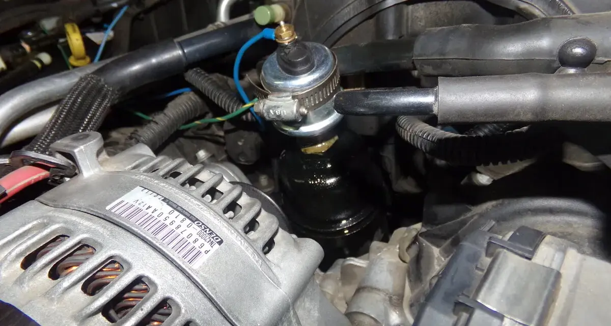 Close-up of a p0520 Dodge engine bay, showing the alternator and a fuel pressure regulator.