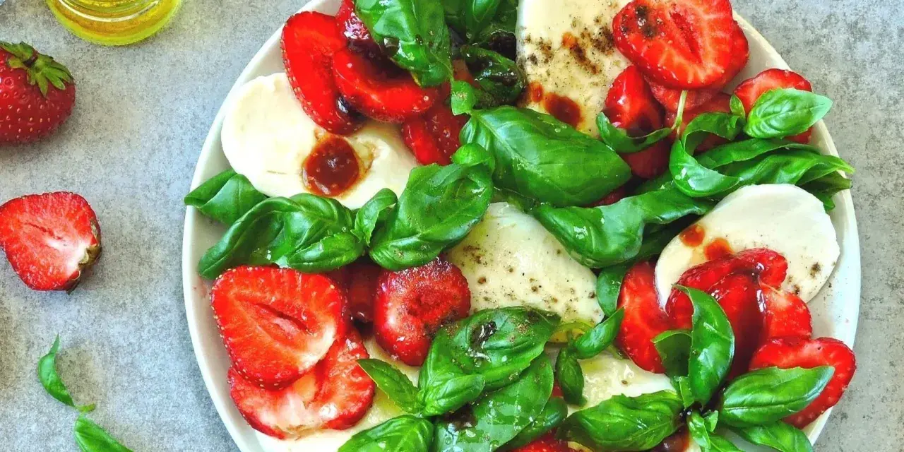 Sałatka z truskawkami, mozzarellą i bazylią. Choć mozzarella zawiera cholesterol, to w tej wersji z owocami i ziołami jest pyszną przekąską.