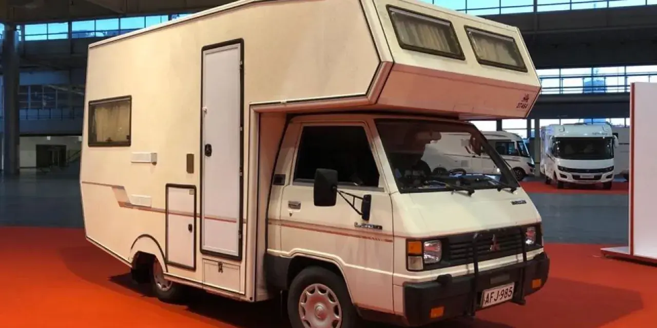 Biały kamper Mitsubishi L300 z zabudową mieszkalną, gotowy na przygody.