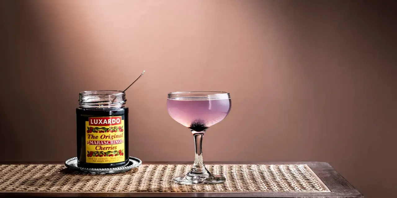 En elegant aviation drink med en burk Luxardo maraschino-körsbär, redo att förhöja smaken.