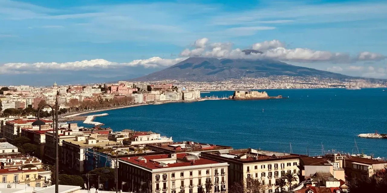 Vue panoramique de Naples avec le Vésuve en arrière-plan, un voyage inoubliable.