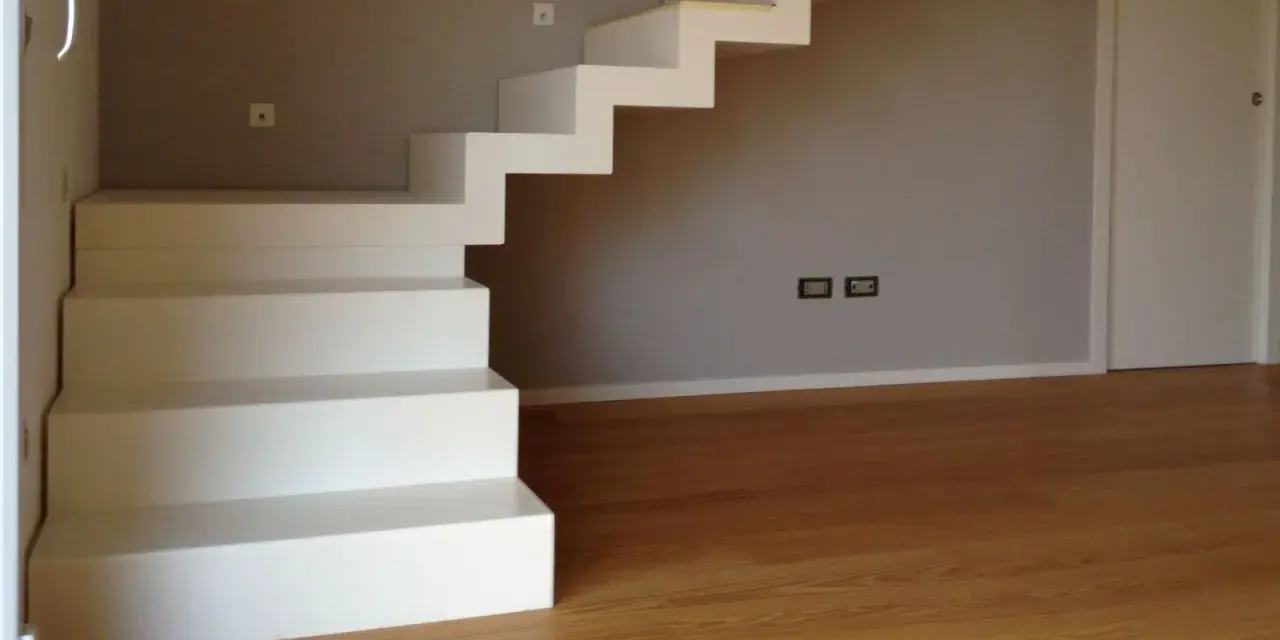 La larghezza scala interna è ben definita da gradini bianchi e minimalisti che salgono verso l'alto.