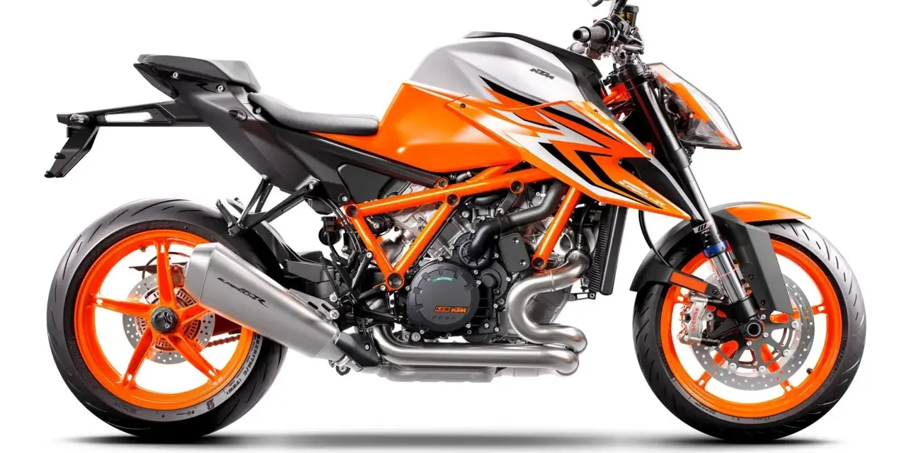 Pomarańczowo-biały motocykl KTM 1290 Super Duke R z agresywnymi grafikami i pomarańczowymi felgami.