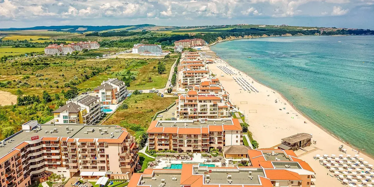 Widok z lotu ptaka na kurort nad Morzem Czarnym w Bułgarii. Zastanawiasz się, ile się leci do Bułgarii? Tuż obok plaży z leżakami i parasolami, rozciągają się hotele i apartamenty.