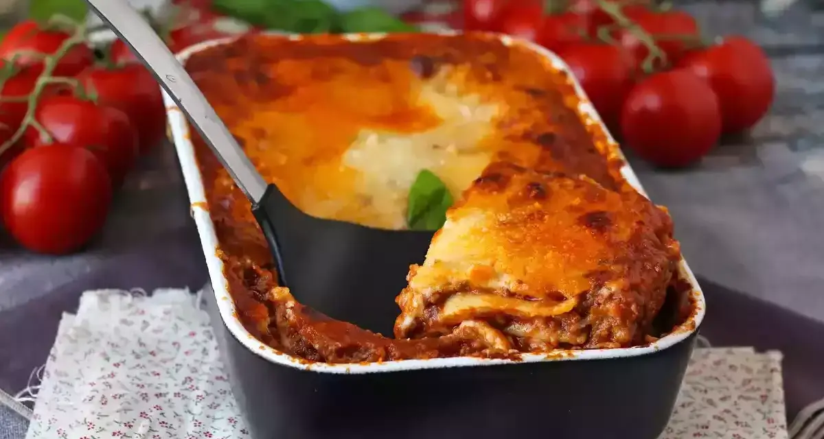 Gorąca, zapiekana lasagne bolognese z sosem pomidorowym i serem, gotowa do podania.