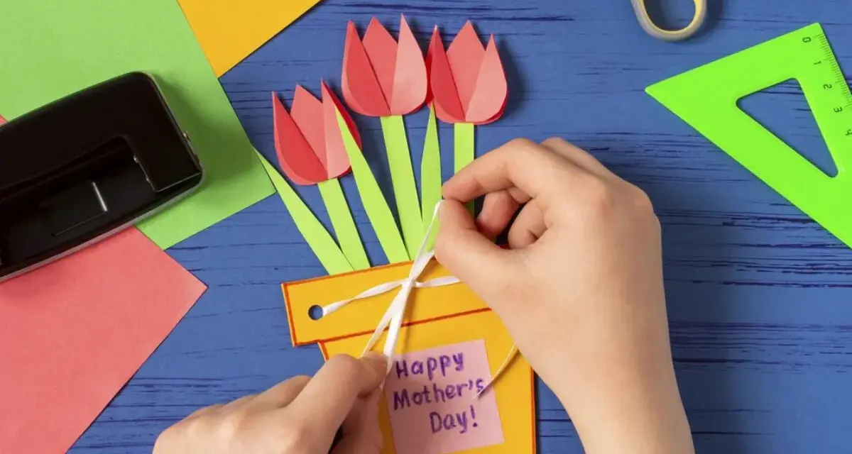 Dziecko tworzy kartkę z tulipanami i napisem "Happy Mother's Day!". To piękne prezenty robione przez dzieci.