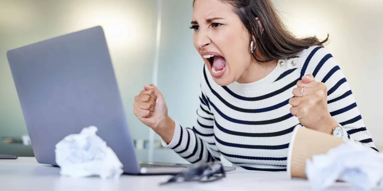 Wütende Frau schreit vor Laptop, frustriert über Probleme im **bad neighbourhood**.
