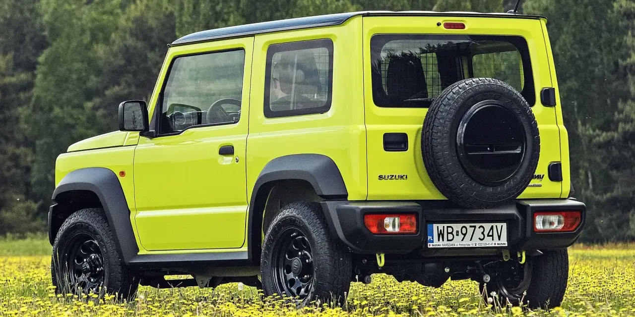 Jaskrawożółty Suzuki Jimny na tle łąki z żółtymi kwiatami. Sprawdź aktualną suzuki jimny cena i wybierz się na przygodę!