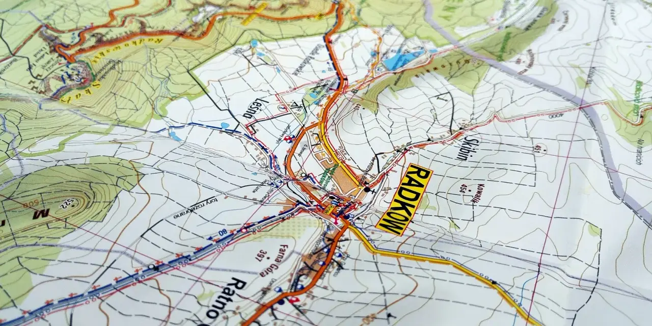 Mapa turystyczna z zaznaczonymi szlakami i miejscowościami, w tym Radkowem. Widoczne są **góry stołowe** i ukształtowanie terenu.