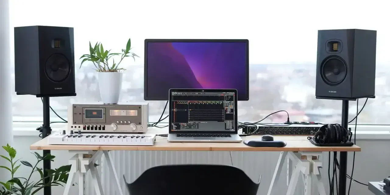 Studio z monitorami Adam Audio T7V, laptopem, klawiaturą i mikserem. Idealne miejsce do tworzenia muzyki.
