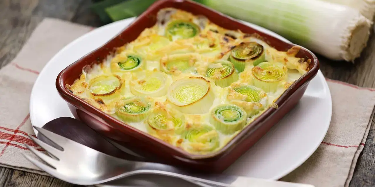 Puerros al horno gratinados, tiernos y dorados, listos para disfrutar.