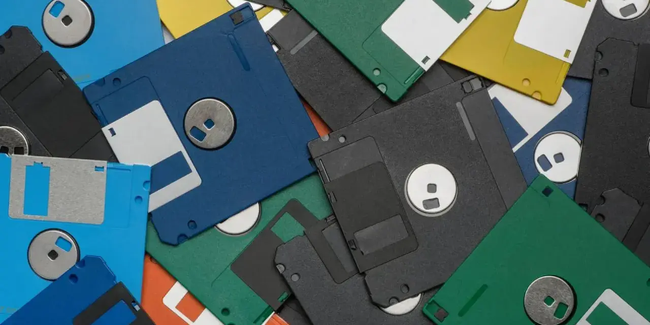 Montón de disquetes de colores, algunos con etiquetas blancas. Recuerdos de los juegos antiguos pc.