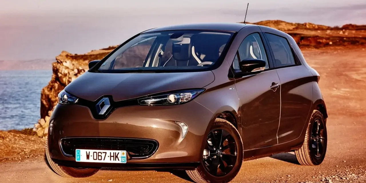Brązowy Renault Zoe na tle morza i klifów. Poznaj jego renault zoe dane techniczne.
