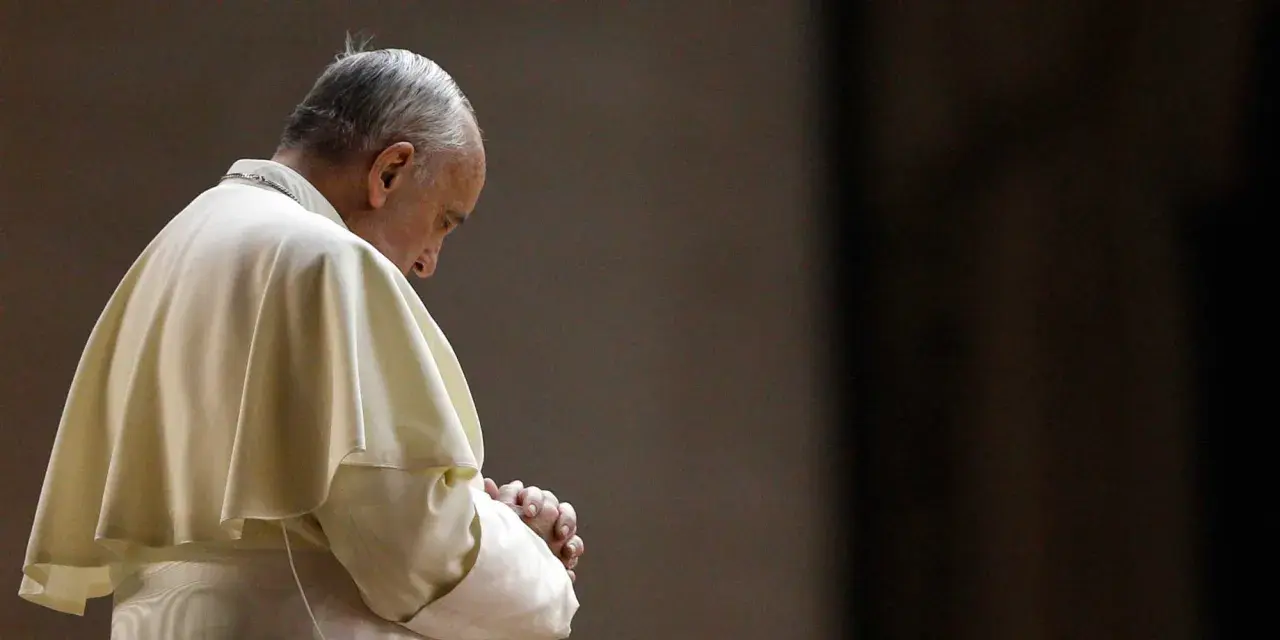 Papież Franciszek w białej szacie, z rękami złożonymi do modlitwy do Ojca Świętego.