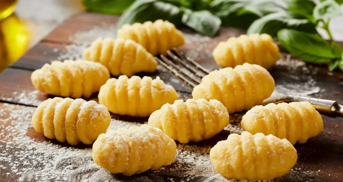 Domowe gnocchi, gotowe do przygotowania według ulubionego gnocchi przepisu. Pachnące bazylią i posypane mąką, czekają na sos.