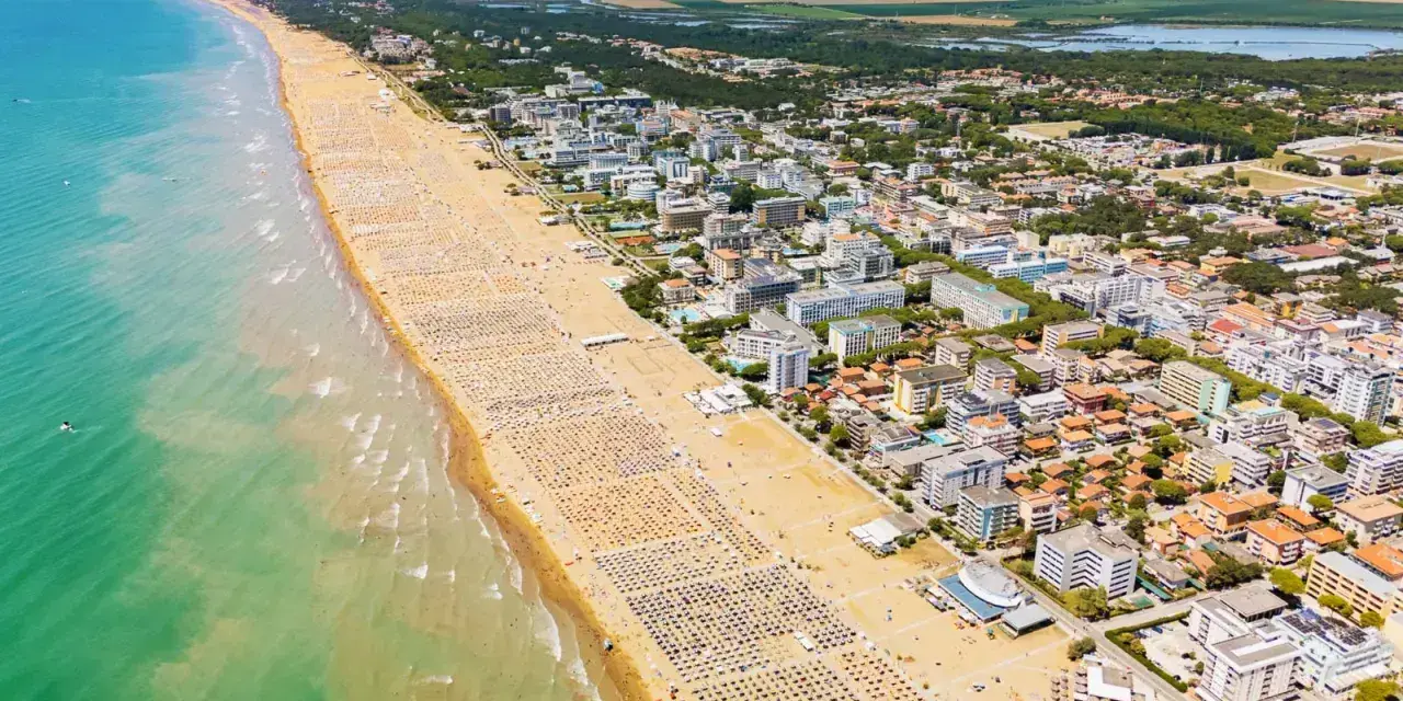 Słoneczna bibione plaża tętni życiem. Tysiące leżaków i parasoli tworzą barwny dywan na piasku, a turkusowe morze zaprasza do kąpieli.