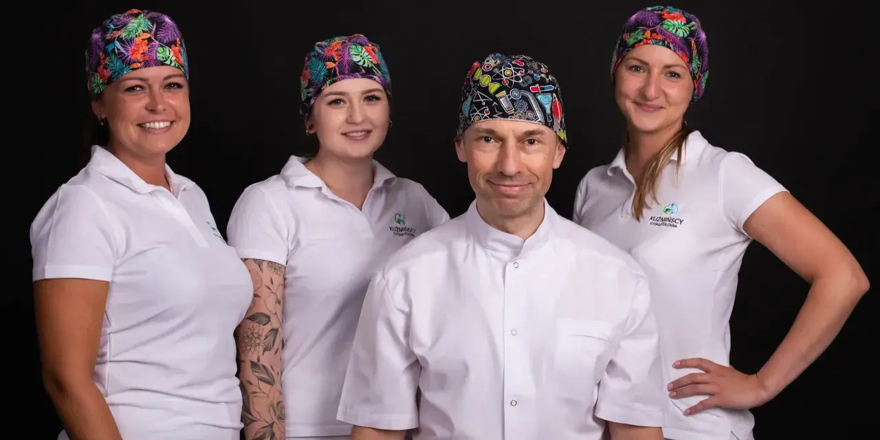 Cztery osoby w białych uniformach i kolorowych czepkach na czarnym tle.