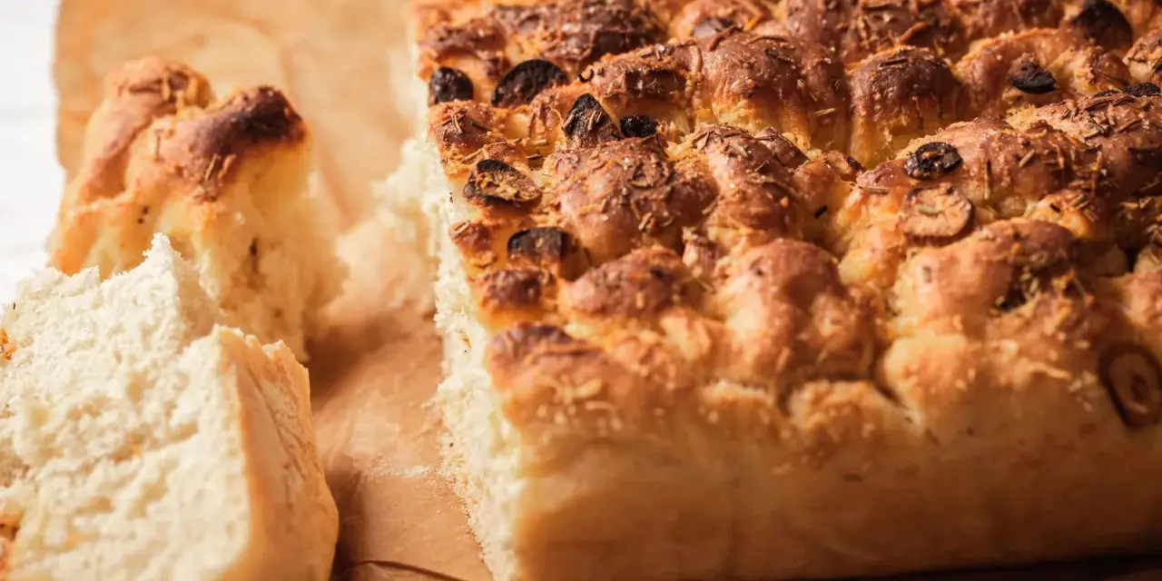 Puszysta focaccia z oliwkami i rozmarynem, idealna do podania. Ten przepis na focaccię jest prosty i szybki.