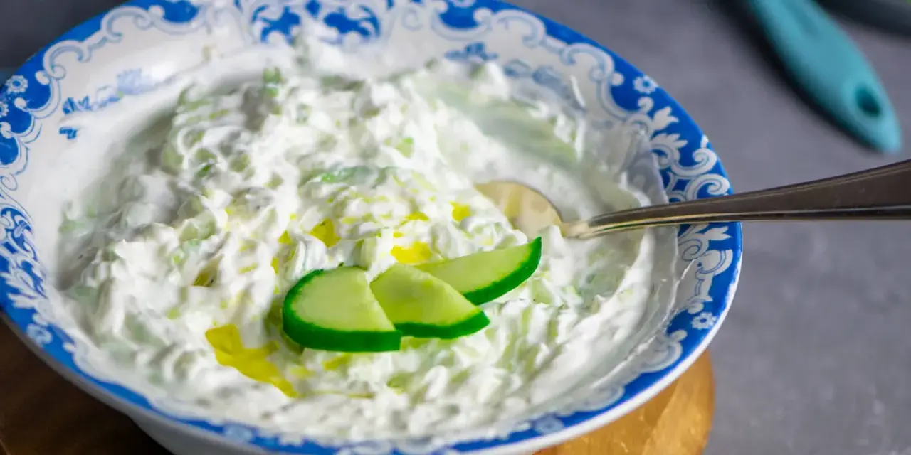 Cremiger Tzatziki-Dip mit Gurkenstücken und Olivenöl, perfekt für ein einfaches Tzatziki Rezept.