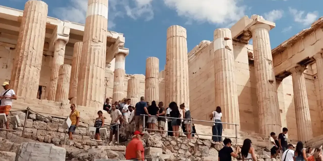 Tourists ascend the rocky path towards the Acropolis, a testament to how hard is the walk up to the Acropolis.