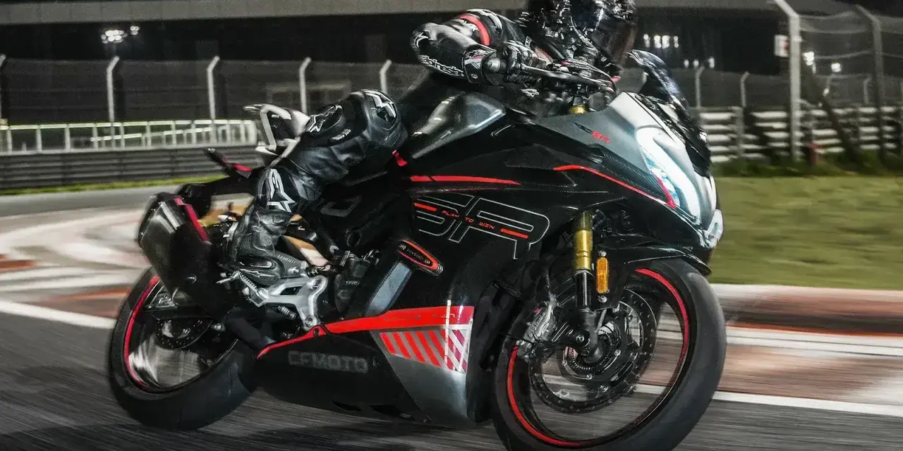 Un pilota in tuta nera sfreccia in pista con la CF Moto 450 SR, puntando alla velocità massima.