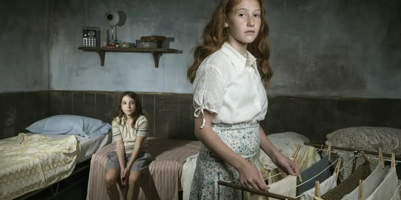 Due bambine in una stanza spartana, una stende il bucato, l'altra siede sul letto. Ricorda l'arminuta storia vera.