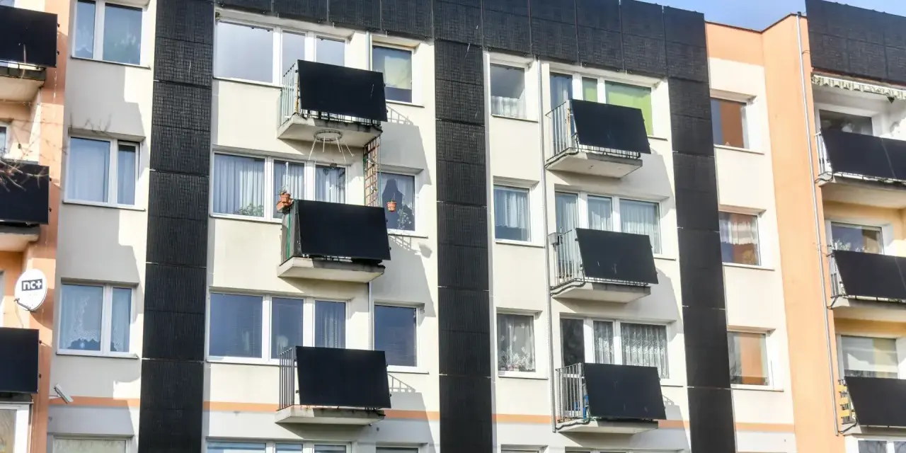 Prawdziwa historia bloku, który zaczął się przechylać po wykopach pod sąsiednią inwestycję. Widok na fasadę budynku z balkonami i oknami.