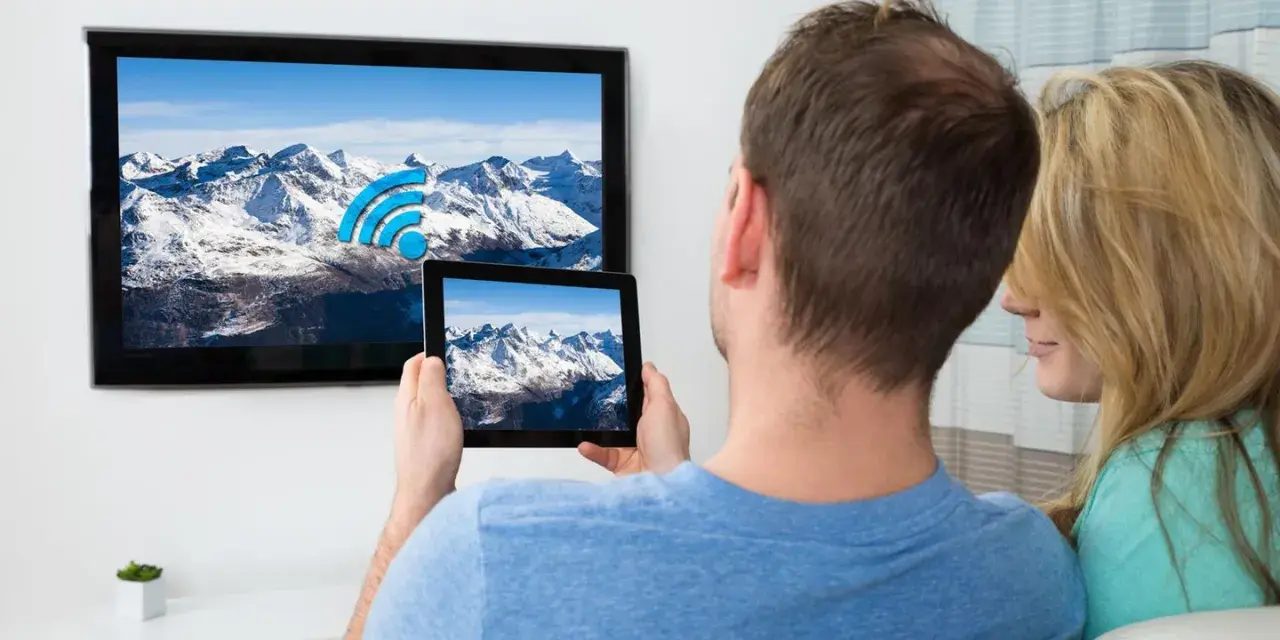 Ein Paar verbindet sein iPad mit dem Fernseher, um die Berglandschaft auf dem großen Bildschirm zu genießen.