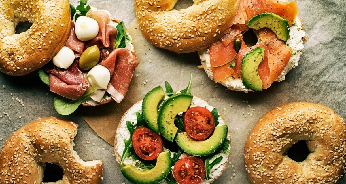 Pyszne bajgle z łososiem, awokado, pomidorami, szynką i mozzarellą – idealne co zamiast chleba na śniadanie czy lunch.