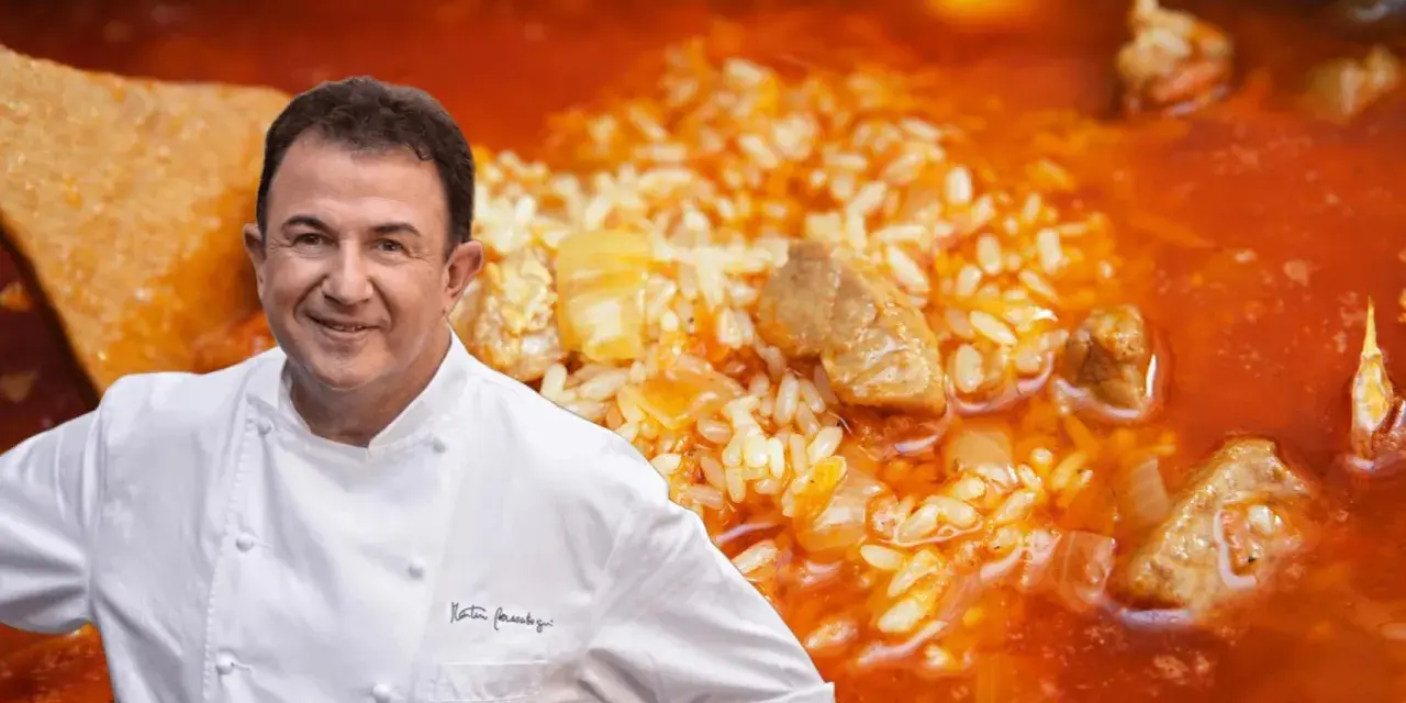 Chef Dani García sonríe junto a un plato de arroz meloso con trozos de atún y carne.
