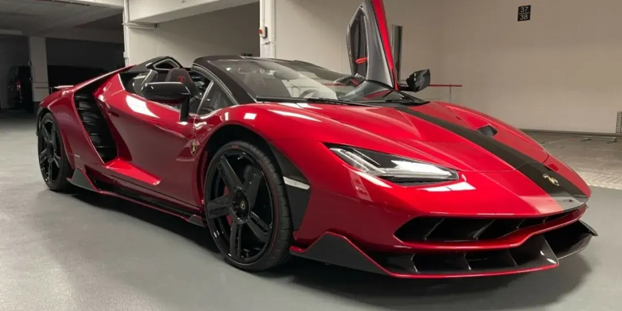 Czerwony kabriolet Lamborghini Centenario z otwartymi drzwiami typu nożycowego.