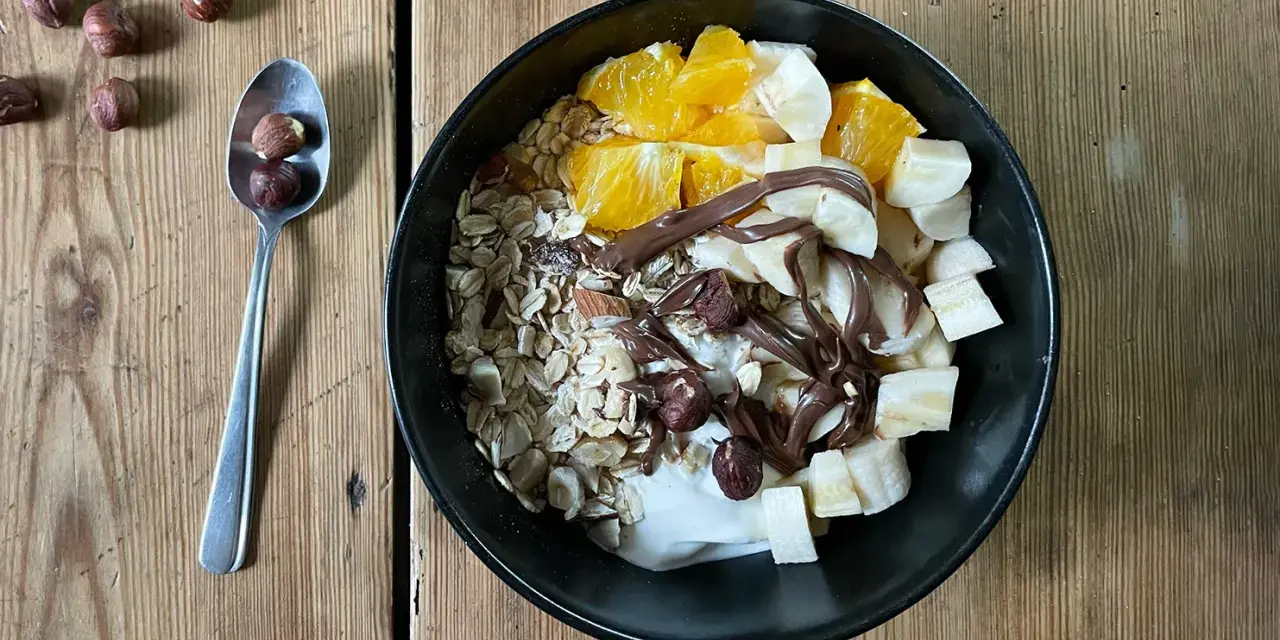 Pyszna owsianka z nutellą, bananem, pomarańczą i orzechami laskowymi. Idealne śniadanie dla łasuchów.