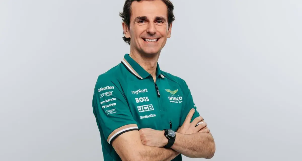 Pedro de la Rosa, con brazos cruzados, sonríe con confianza. Viste un polo verde del equipo Aston Martin Aramco.