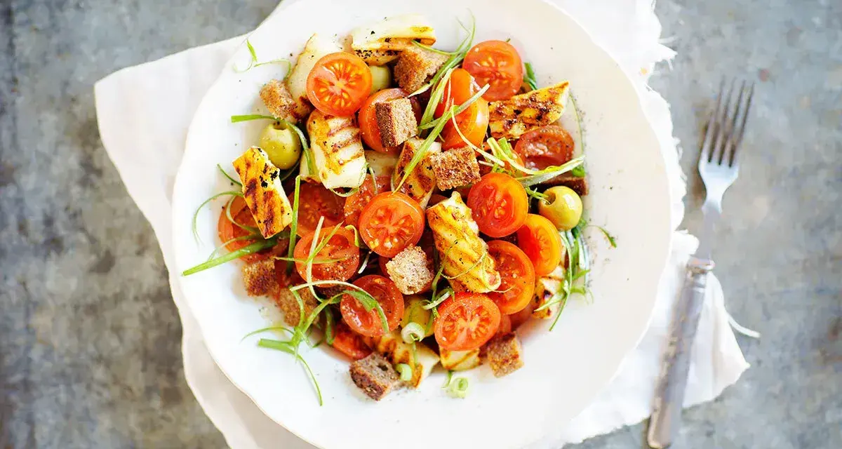 En härlig halloumi sallad med körsbärstomater, krutonger och gröna oliver.